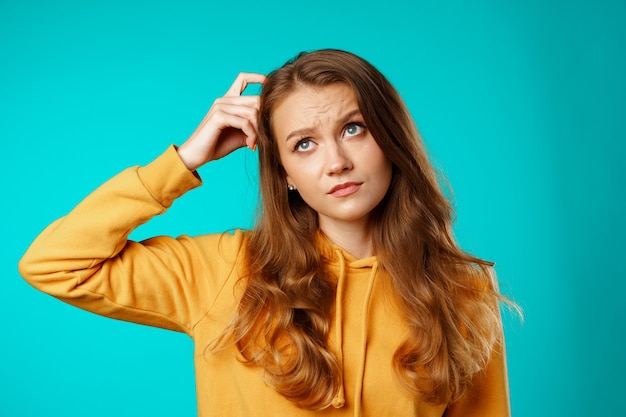 Ritratto dello studio di bella giovane donna casuale che pensa