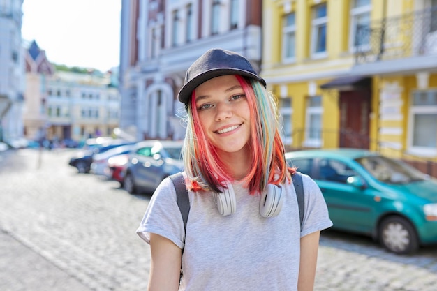 Ritratto di adolescente sorridente alla moda hipster con capelli tinti colorati in berretto nero