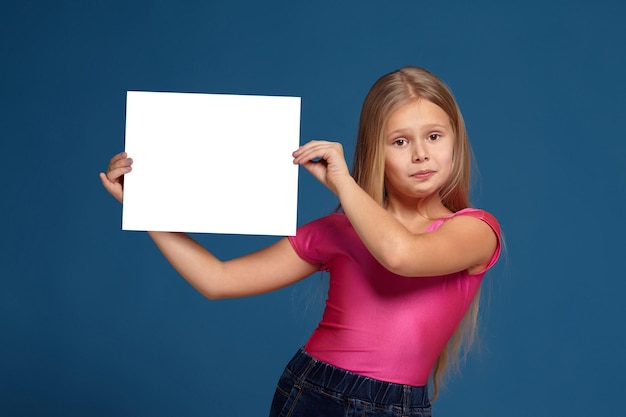 Ritratto di adorabile bambina emotiva su sfondo blu