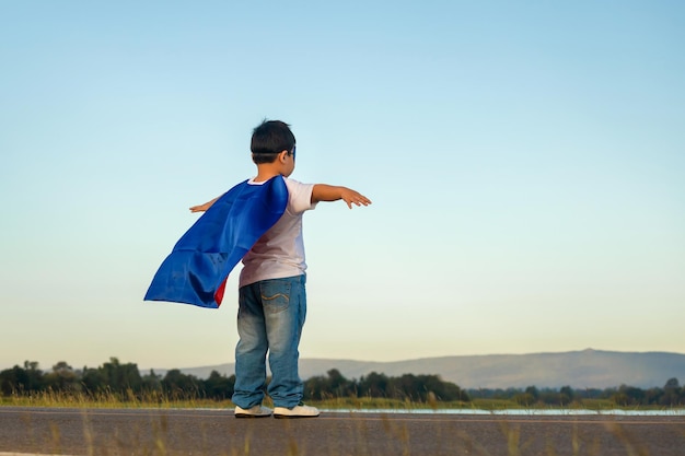 Ritratto di adorabile bambino che si diverte all'aperto Piccolo bambino gioca supereroe