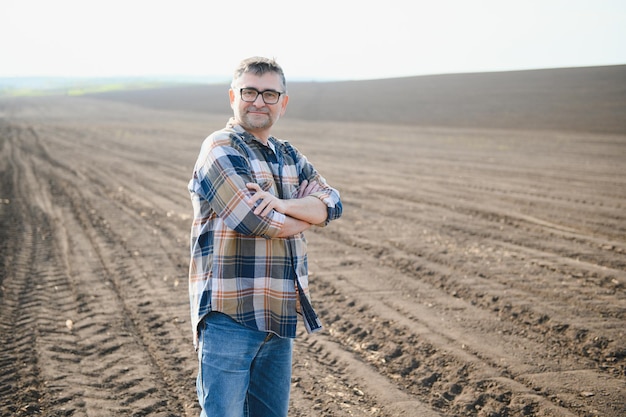 Ritratto di agricoltore anziano con gli occhiali in campo