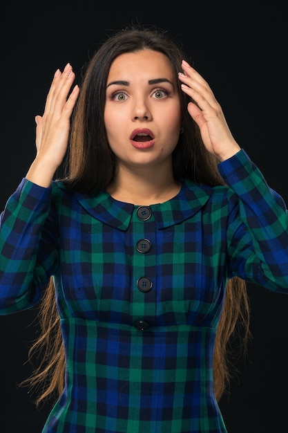 Ritratto di allegra e attraente donna moderna con i capelli lunghi che guarda l'obbiettivo ed esprime sorpresa...