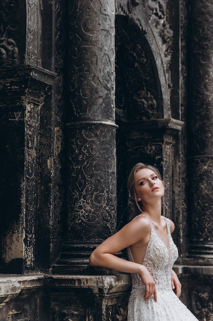 Ritratto di alta moda di giovane donna elegante all'aperto Sposa in abito bianco vicino al vecchio edificio