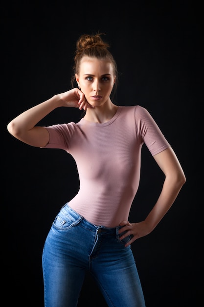 Ritratto di alta moda di giovane donna elegante in top beige e jeans