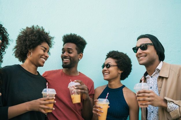 Ritratto di amici afro divertirsi insieme e godersi un buon tempo bevendo succo di frutta fresca.