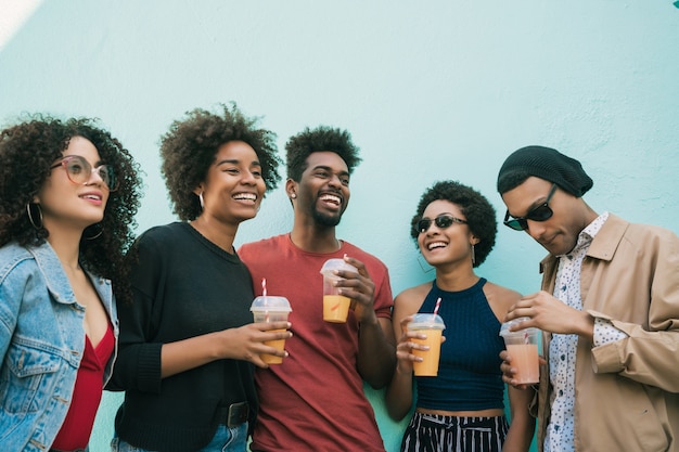 Ritratto di amici afro divertirsi insieme e godersi un buon tempo bevendo succo di frutta fresca.