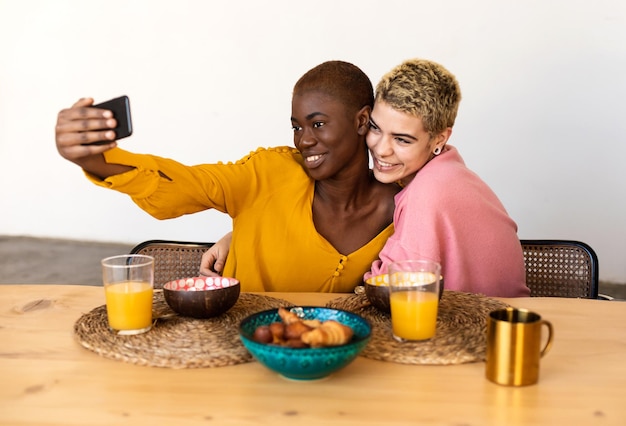 Ritratto di amici sorridenti che usano il cellulare