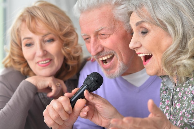 Ritratto di anziani felici che cantano al karaoke