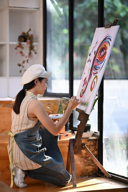 Ritratto di artista femminile dipinto su tela con acqua colorata in studio d'arte