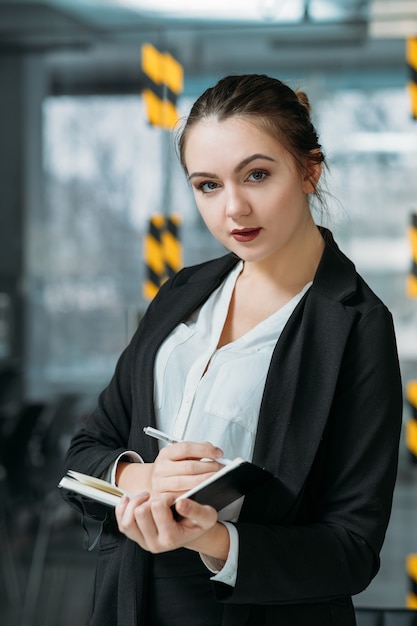 Ritratto di assistente personale. La pianificazione aziendale conta. Giovane donna che prende appunti ascoltando le istruzioni del capo virtuale.