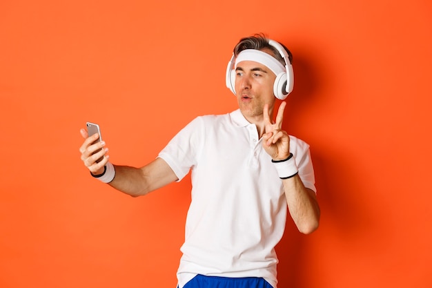Ritratto di attraente atleta maschio di mezza età, prendendo selfie durante l'allenamento