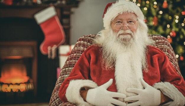 Ritratto di Babbo Natale che tiene la pancia a casa nel soggiorno