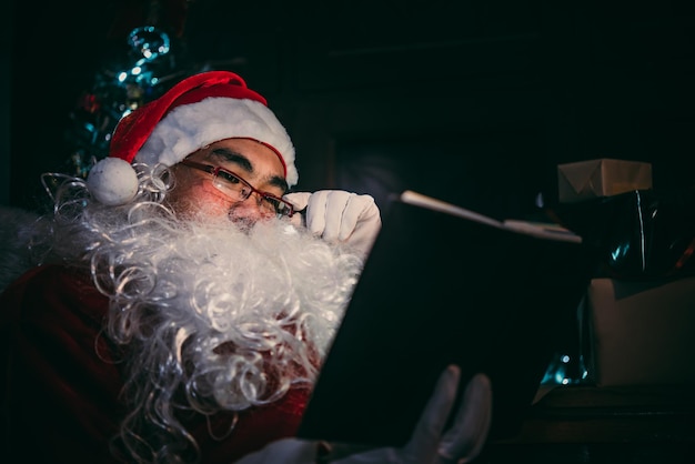 Ritratto di Babbo Natale felice che legge un libroLa gente della Thailandia indossa l'abito di Babbo Natale Invia la felicità per i bambiniBuon NataleBenvenuto all'inverno