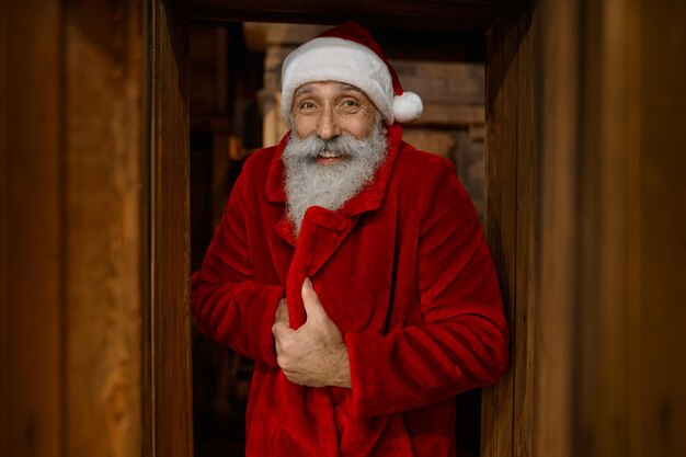 Ritratto di Babbo Natale sorridente avvolto in accappatoio rosso sensazione di freddo. Trattamenti di contrasto in sauna