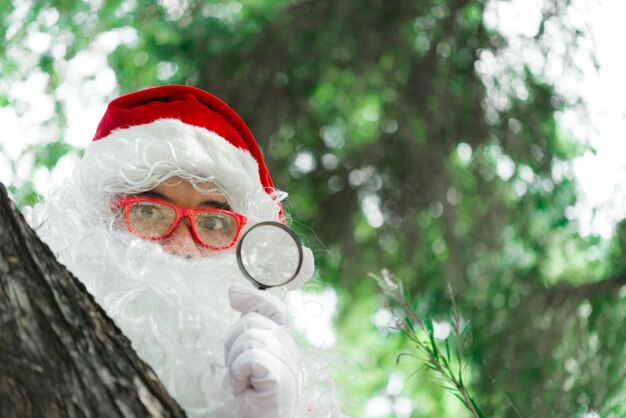 Ritratto di babbo natale sulla luce del bokeh sotto l'alberoLa gente della Thailandia ha inviato la felicità per i bambiniBuon NataleBenvenuti in inverno