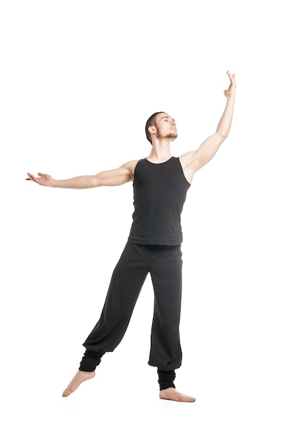 Ritratto di ballerino maschio in nero in posa con il braccio alzato.Isolato