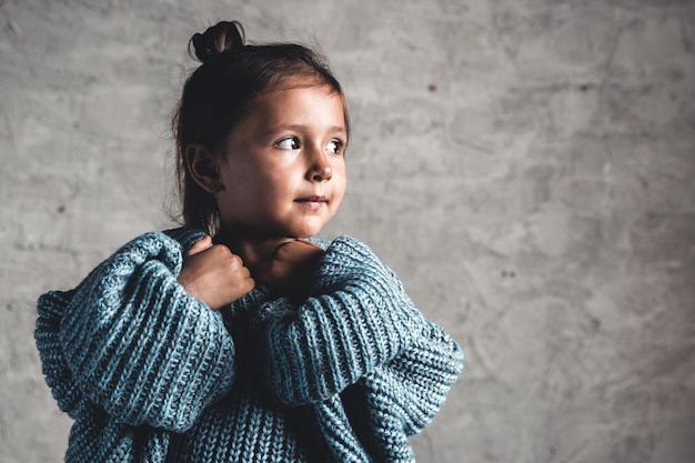 Ritratto di bambina bambino moda su sfondo grigio muro