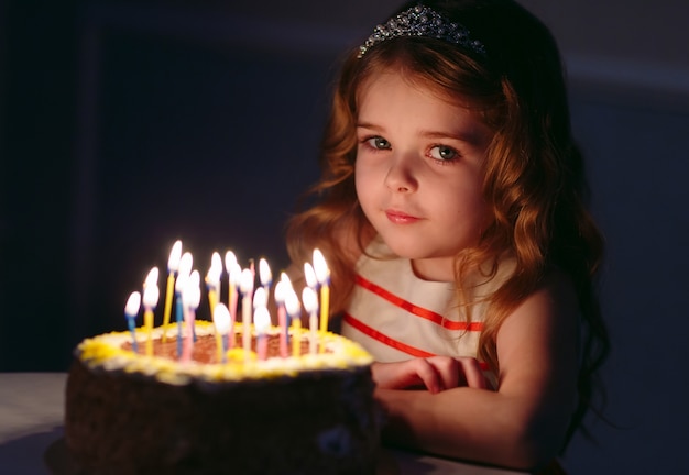 Ritratto di bambina carina con torta di compleanno