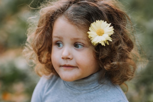 ritratto di bambina carina in camicia blu con fiore nei capelli caduta banner carta di autunno