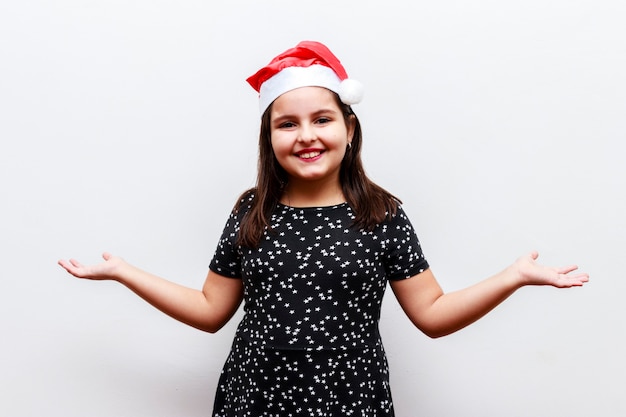 Ritratto di bambina caucasica con cappello di natale, sfondo bianco