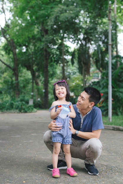 Ritratto di bambina che abbraccia il suo papà con la natura, concetto di famiglia