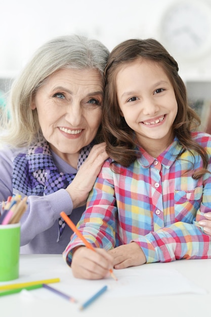 Ritratto di bambina che disegna con la nonna a casa