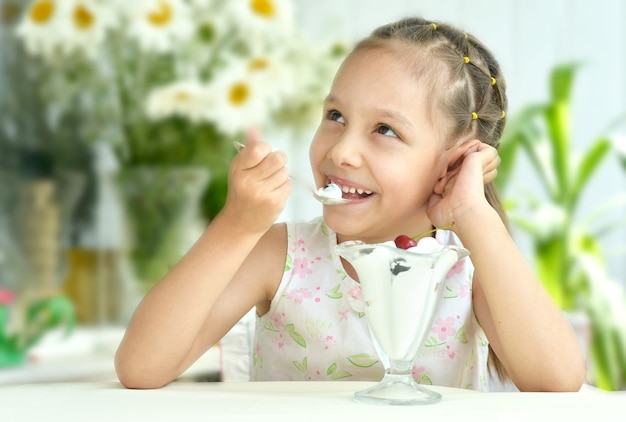 Ritratto di bambina che mangia dessert con frutti di bosco