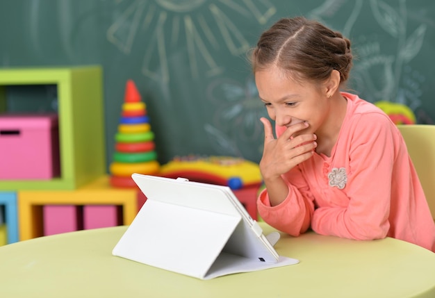 Ritratto di bambina che utilizza tablet a casa