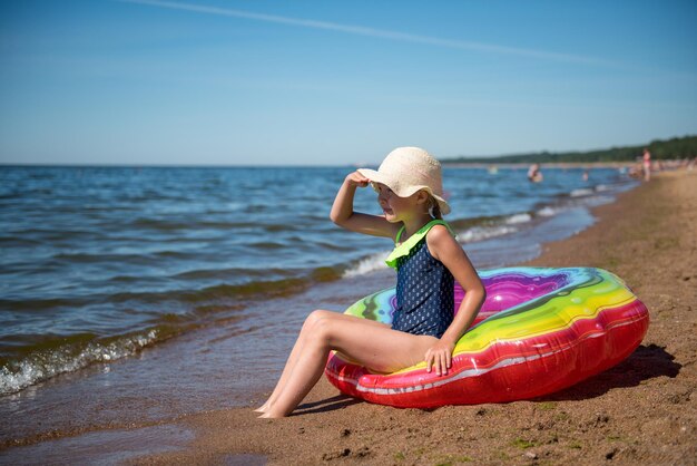 Ritratto di bambina con cerchio di gomma gonfiabile sulla spiaggia