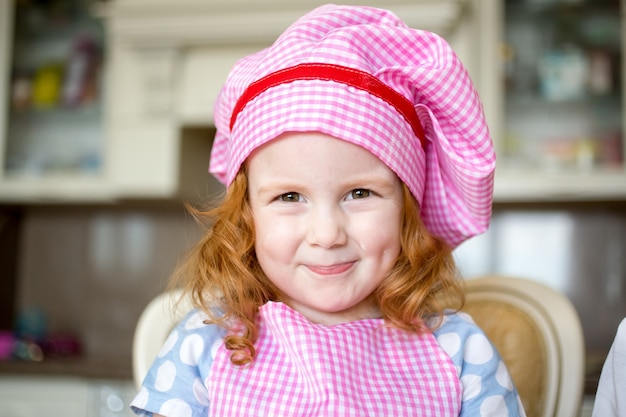 Ritratto di bambina felice che indossa cappello di chef