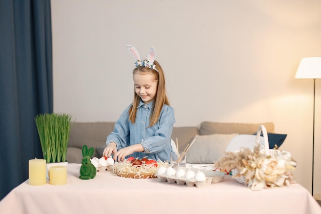 Ritratto di bambina in piedi nella moderna cucina leggera con uova di Pasqua