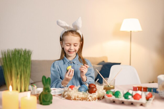 Ritratto di bambina in piedi nella moderna cucina leggera con uova di Pasqua