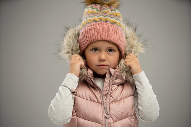 Ritratto di bambina in posa in giacca calda e cappello isolato su sfondo bianco Copiare lo spazio per l'annuncio