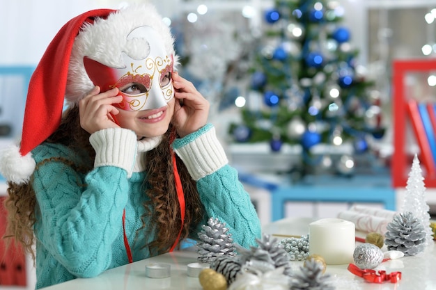 Ritratto di bambina sorridente che si prepara per il Natale, indossando la maschera