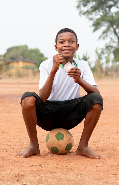 Ritratto di bambino africano con pallone da calcio
