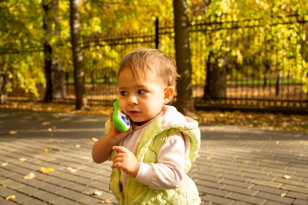 ritratto di bambino carino che gioca parlando su un telefono giocattolo.