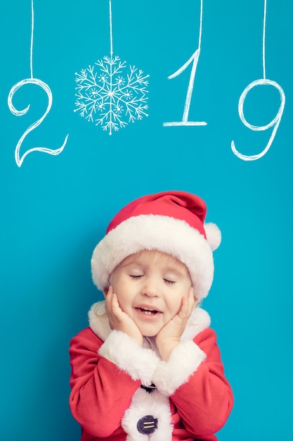 Ritratto di bambino che indossa il costume di Babbo Natale. Kid divertirsi nel periodo natalizio. Buon Natale concetto