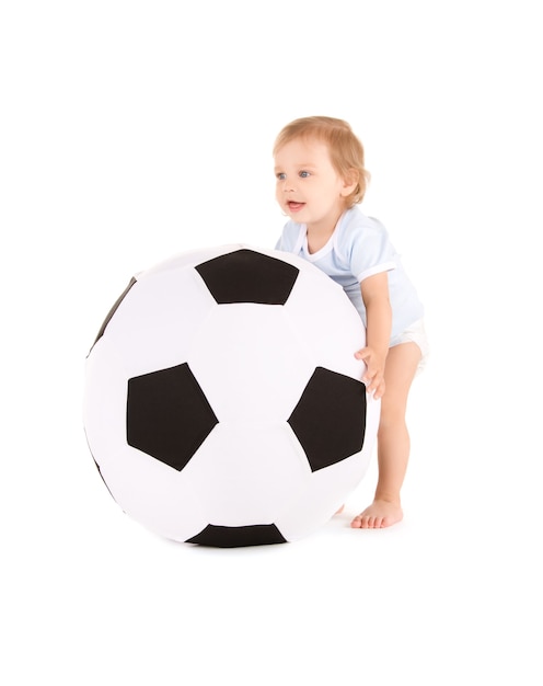 Ritratto di bambino con pallone da calcio su muro bianco