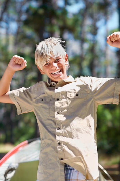 Ritratto di bambino o braccia sollevate in natura per il successo vincente o obiettivo in vacanza vacanza nel bosco estate forestale o ragazzo maschio eccitato con il sorriso per la vittoria libertà o campeggio nel bosco o parco