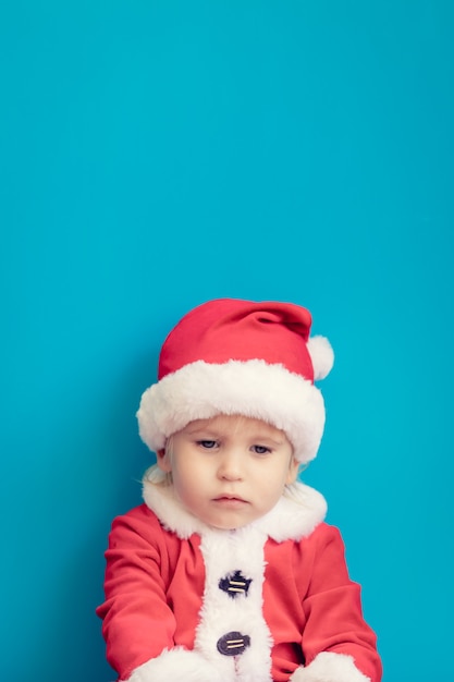 Ritratto di bambino triste. Bambino divertente che indossa il costume di Babbo Natale. Concetto di vacanza di Natale