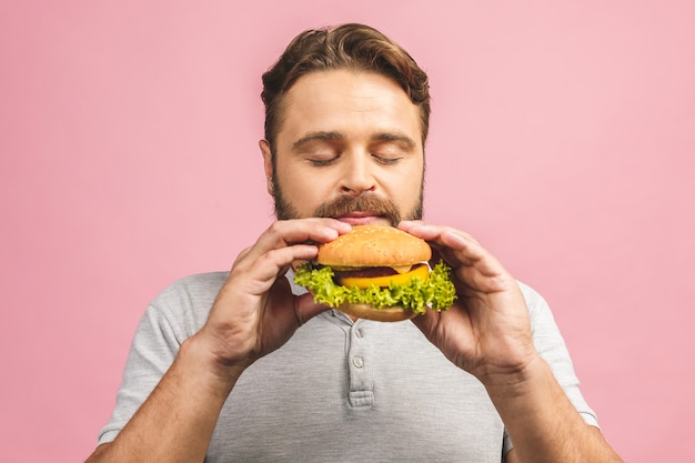 Ritratto di bel giovane uomo mangiare hamburger