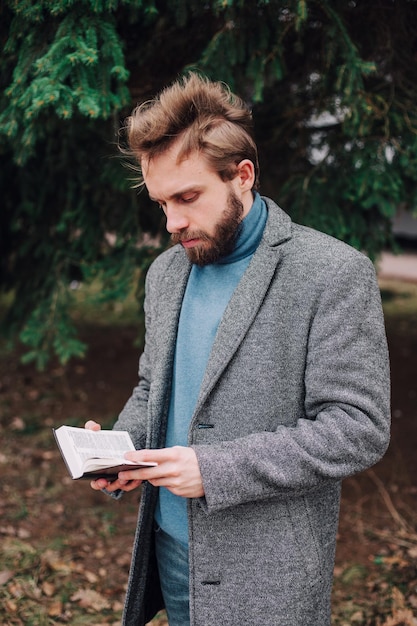 Ritratto di bell'uomo barbuto che legge il libro e si rilassa Effetto film sfocato sullo sfondo orizzontale