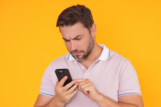 Ritratto di bell'uomo che utilizza lo smartphone in chat facendo post sui social media Uomo d'affari chiama al telefono isolato su sfondo studio Blogger che parla al telefono
