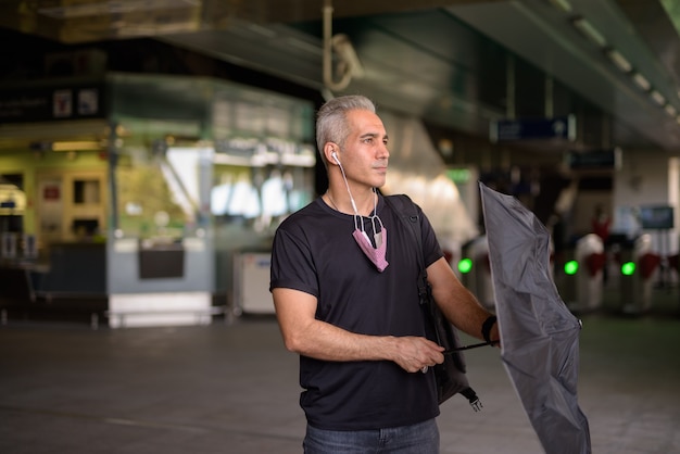 Ritratto di bell'uomo persiano con i capelli grigi alla stazione del treno del cielo