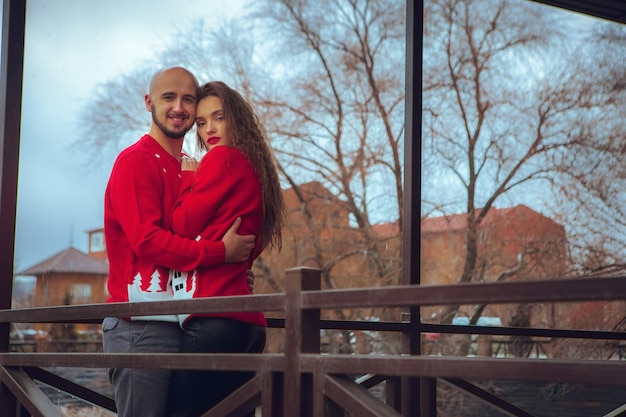 Ritratto di bella coppia abbracci su un balcone in inverno. umore natalizio