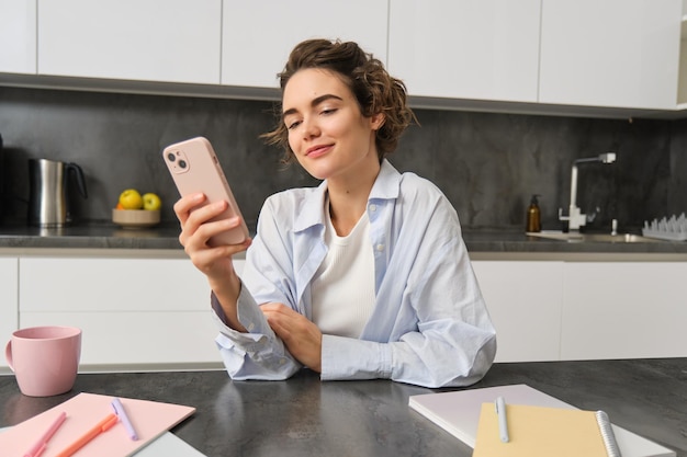 Ritratto di bella donna a casa che tiene acquisti online sullo smartphone dall'app del telefono cellulare
