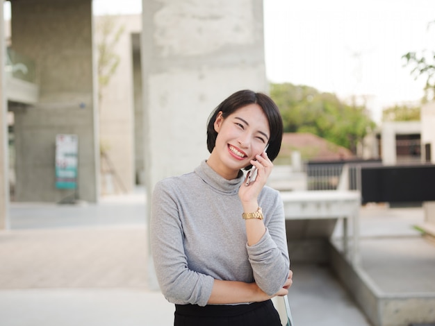 Ritratto di bella donna asiatica con il cellulare in cerca giovane donna d&#39;affari