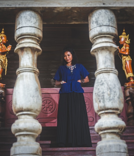 Ritratto di bella donna asiatica con il vestito locale, in piedi in pubblico Temple at campagna di Thai