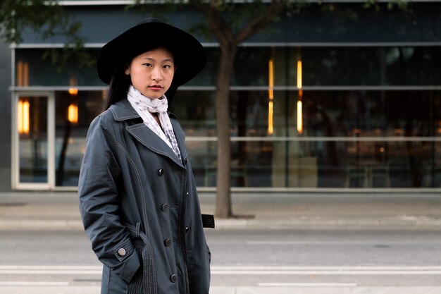 Ritratto di bella donna asiatica in cappello e cappotto