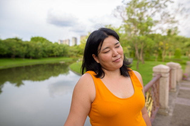 Ritratto di bella donna asiatica in sovrappeso rilassante presso il parco della città di Bangkok, Thailandia